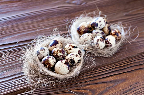 Huevos de codorniz de Pascua en el pesebre y un fondo de madera . — Foto de Stock