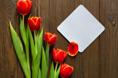 kırmızı lale ve kraft zarf ahşap arka plan üzerinde