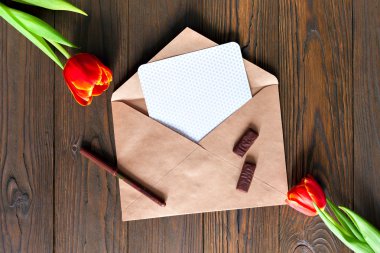 kırmızı lale ve kraft zarf ahşap arka plan üzerinde