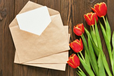 kırmızı lale ve kraft zarf ahşap arka plan üzerinde