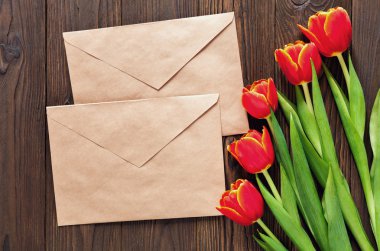 kırmızı lale ve kraft zarf ahşap arka plan üzerinde