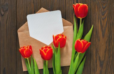 kırmızı lale ve kraft zarf ahşap arka plan üzerinde