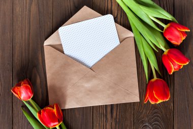 kırmızı lale ve kraft zarf ahşap arka plan üzerinde