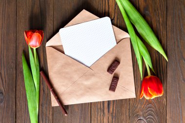 kırmızı lale ve kraft zarf ahşap arka plan üzerinde