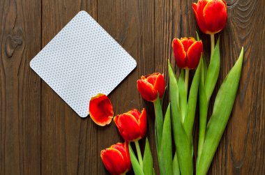 kırmızı lale ve kraft zarf ahşap arka plan üzerinde