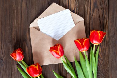 kırmızı lale ve kraft zarf ahşap arka plan üzerinde