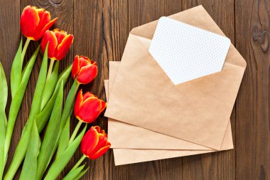 kırmızı lale ve kraft zarf ahşap arka plan üzerinde