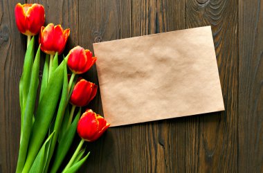 kırmızı lale ve kraft zarf ahşap arka plan üzerinde