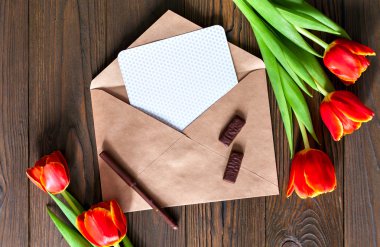 kırmızı lale ve kraft zarf ahşap arka plan üzerinde