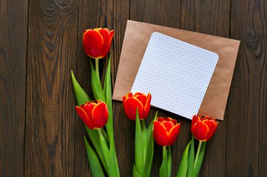 kırmızı lale ve kraft zarf ahşap arka plan üzerinde