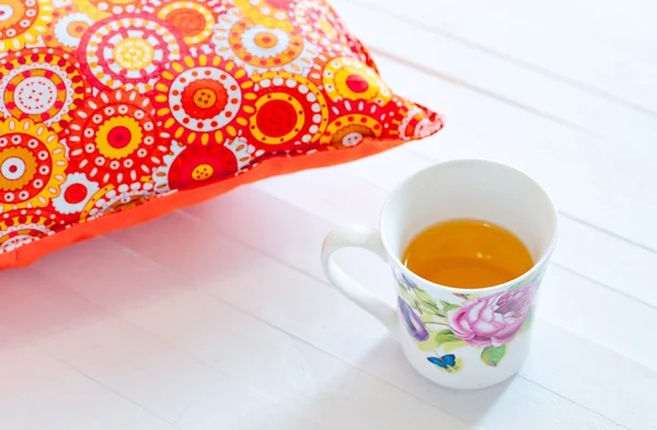 Цветные уютные подушки и чашка чая ручной работы — стоковое фото