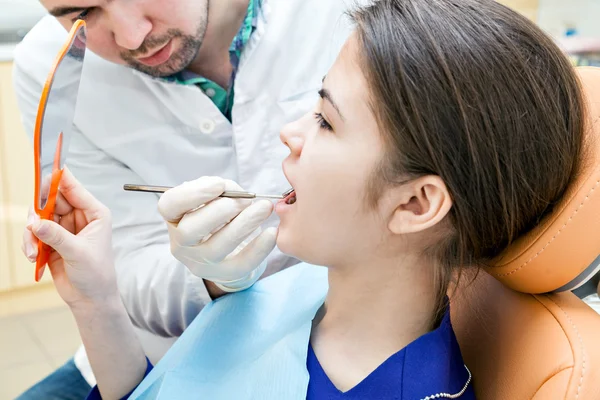 Dentista en una clínica dental. La chica en la recepción en la silla de dentistas . — Foto de Stock