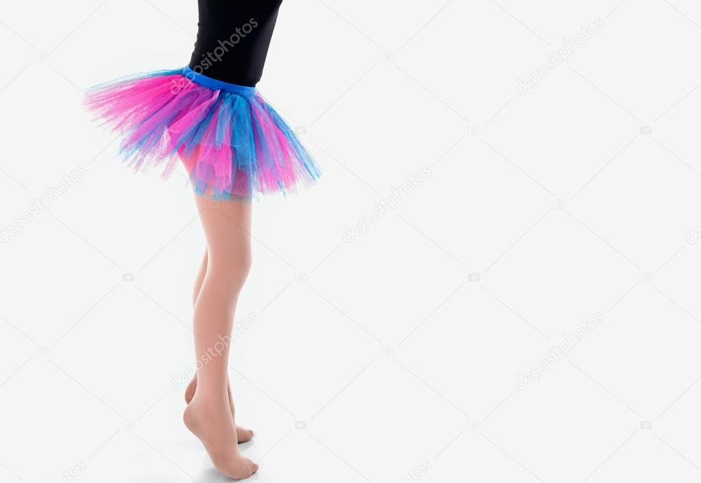 Little Ballerina in tutu on a white studio background. Studying dance is busy doing the exercises