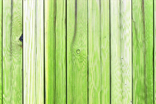 A fragment of an old wooden fence. Painted wooden planks as a background with copy space. Wooden rustic background or painted wood boards texture. Old peeling green paint. — Stock Photo, Image