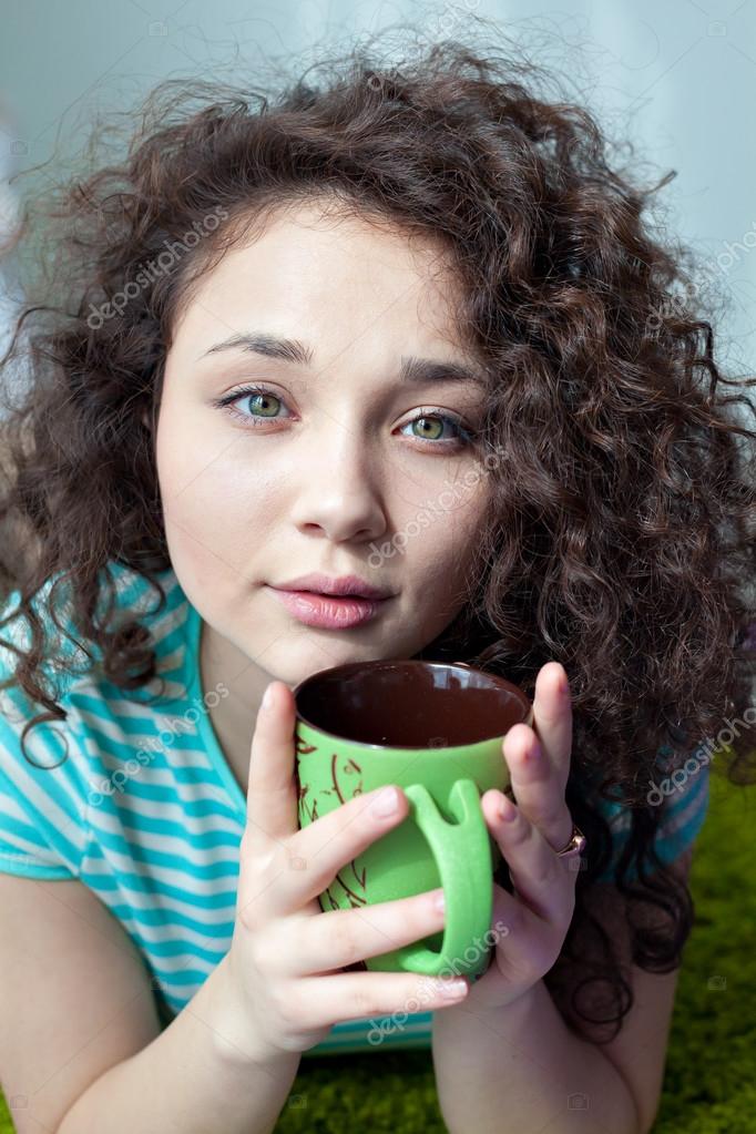 Portrait Of A Beautiful Young Girl With Brown Curly Hair Drink