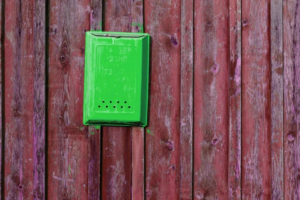 Texture of old wooden planks, painted in dark red color as a background. Green box for letters.