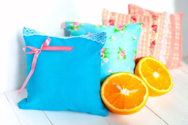 aromaterapi yastıklar, aromatizasyon alanı. Dört küçük dekoratif yastıklar dantel ile mavi ve pembe soluk. El yapımı. Beyaz ahşap arka plan ve turuncu yarıları. İyi bir ruh hali için vitaminler.