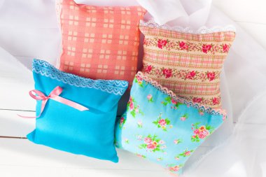 aromaterapi yastıklar, aromatizasyon alanı. Dört minyatür dekoratif yastıklar soluk mavi ve dantel pembe. El yapımı. iyi bir ruh hali için. Beyaz ahşap arka plan. Ev tekstili.