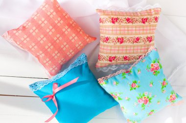 aromaterapi yastıklar, aromatizasyon alanı. Dört minyatür dekoratif yastıklar soluk mavi ve dantel pembe. Beyaz ahşap arka plan. Ev tekstili. El yapımı. iyi bir ruh hali için.