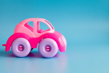 Çocuklar için mavi bir arka plan üzerinde renkli plastik oyuncak araba.