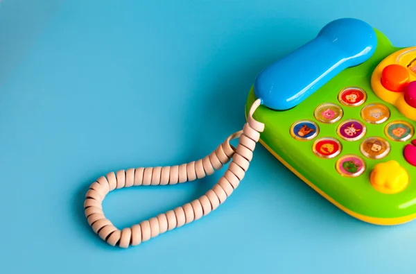Çocuklar için mavi bir arka plan renkli plastik oyuncak cep telefonu.