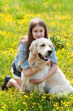 woman and golden retriever in a field with flowers