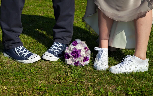 Paar, das auf dem Rasen steht. Braut und Bräutigam in Turnschuhen — Stockfoto