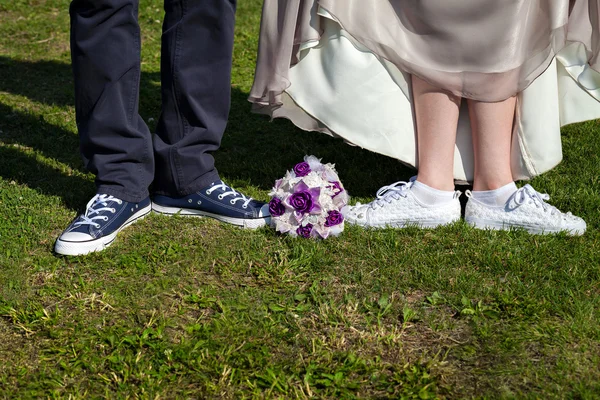 Paar, das auf dem Rasen steht. Braut und Bräutigam in Turnschuhen — Stockfoto