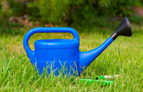 Kolorowy ogród narzędzia, niebieskie plastikowe konewka — Zdjęcie stockowe