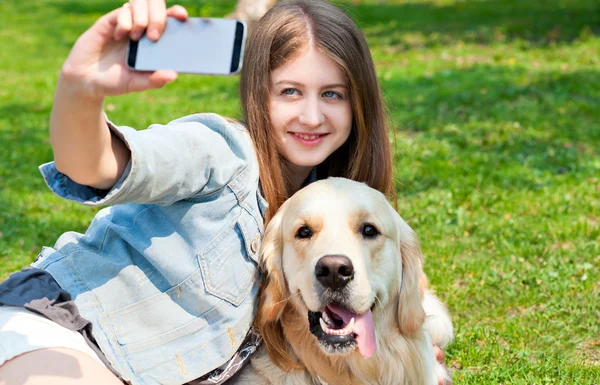 Mädchen und ihr Hund Selfie Sommer auf einem Hintergrund aus grünem Gras. — Stockfoto