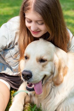 Genç bir kadın ve onu köpek golden retriever parkta bir yaz gününde