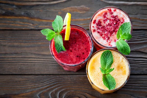 Taze meyve Smoothies. Çeşitli meyve smoothies ahşap bir masa üzerinde. güler yüzlü kavramı