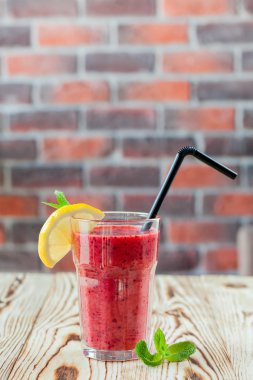 Taze meyve yüzlü berry. Bir bardak portakal ve nane ahşap bir masa üzerinde kırmızı yüzlü. güler yüzlü kavramı