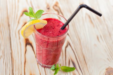 Taze meyve yüzlü berry. Bir bardak portakal ve nane ahşap bir masa üzerinde kırmızı yüzlü. güler yüzlü kavramı