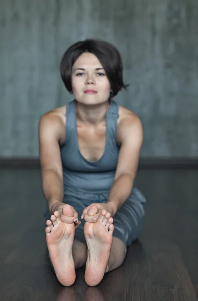 Młoda kobieta praktykowania jogi na tle szarego betonu. Tła miejskiego. Obrazu monochromatycznego. — Zdjęcie stockowe