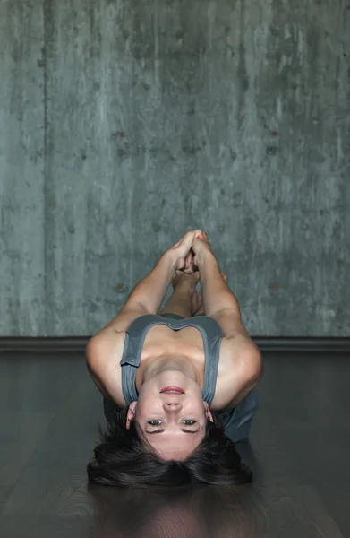 Junge Frau praktiziert Yoga auf einem Hintergrund aus grauer Betonwand. Urbaner Hintergrund. Monochromes Bild. — Stockfoto