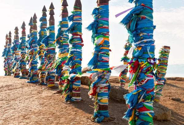 Otostop sonrası serge için geleneksel ahşap direkleri. Olkhon, Buryat Region, Rusya, Sibirya'da dua bayrakları. — Stok fotoğraf