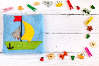 Çocuk oyuncak motor gelişimi için renkli polar yapılmış. Beyaz ahşap arka plan üzerinde plastik boncuk ve heykelcikler ile dolu bir yün bir gemi ile Kese. el yapımı oyuncaklar. Mutlu çocukluk.