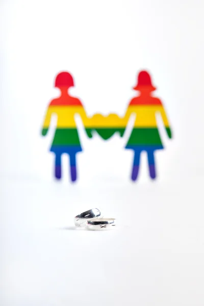 Dvě stříbrné kroužky a dvě papíru barvy vlajky lidské homos — Stock fotografie