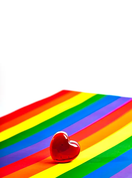 Červené sklo srdce je v pozadí barvy vlajky homos — Stock fotografie