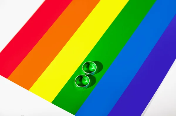 Logo LGBT. Dos anillos de plata se encuentran en el fondo en los colores — Foto de Stock