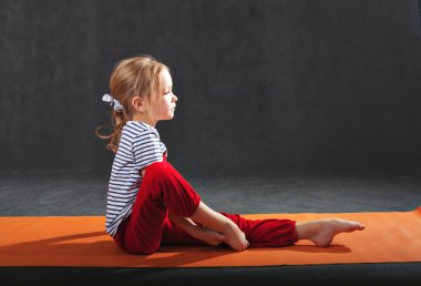 Küçük kız için yoga mat egzersizleri yapıyor. Ellerini çek 