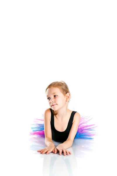Kleine Balletttänzerin auf dem Boden liegend auf weißem Hintergrundgestell — Stockfoto