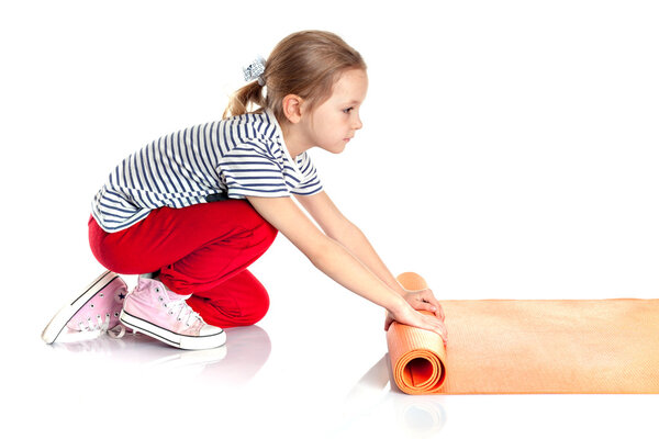 little girl doing gymnastic exercises on an orange yoga mat. exe