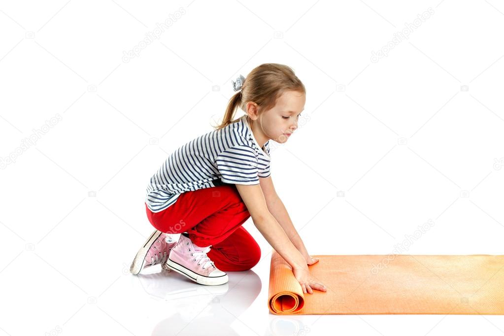 little girl doing gymnastic exercises on a yoga mat. doing fitne