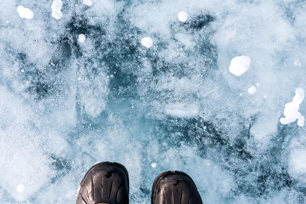 Pé humano em sapatos no gelo do Lago Baikal . — Fotografia de Stock