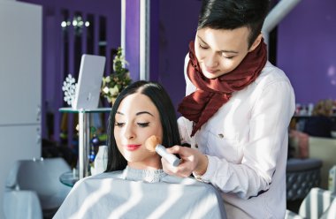 Güzel genç kız bir güzellik salonu. Kalıcı makyaj yapıyor.