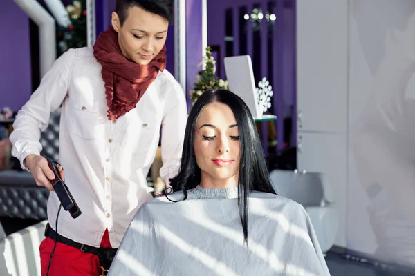 Menina com cabelo preto longo em uma cadeira de barbeiro .. — Fotografia de Stock