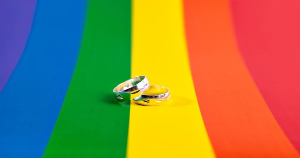 Twee ringen op de achtergrond van Regenboogvlag — Stockfoto