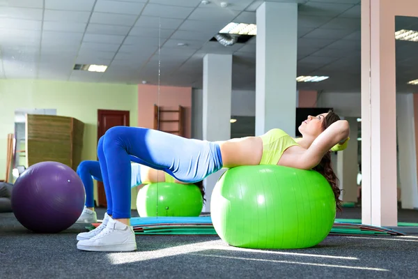 Pilates žena strana ohnout fitball cvičení cvičení v tělocvičně krytého švýcarské míč — Stock fotografie